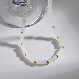 Dettaglio delle perle traslucide a forma di bambù e distanziatori dorati sulla collana