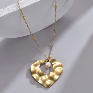 Elegant gold heart pendant necklace with hammered texture and a white pearl accent
