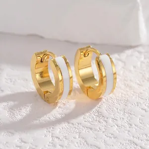 Ethnic style gold hoop earrings with white enamel inlay and polished metal finish