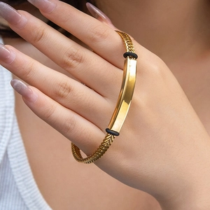 Bracelet chaîne de blé dorée minimaliste avec barre courbée polie porté au poignet