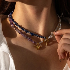 Collier superposé en acier titane avec éclats de pierres, perles et pendentifs dorés