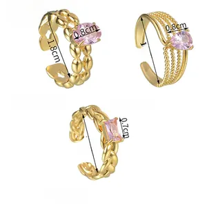 Detailed macro view of three vintage gold adjustable rings with pink zircon inlays