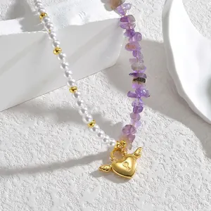 Détail du collier avec perles blanches, pierres violettes et pendentif cœur ailé