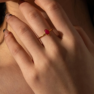 Minimalist gold titanium steel ring with oval ruby gemstone and milgrain edge detailing