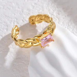Detailed close-up of a gold braided open ring featuring a rectangular pink zircon stone