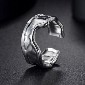 Macro detail of men's geometric stainless steel ring with liquid lava metal texture