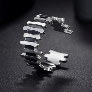 Close-up of a silver geometric ring with black enamel inlay and adjustable opening
