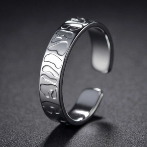 Detail of adjustable silver steel ring with relief texture and polished inner band