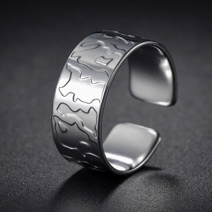Detail of silver geometric wide ring with irregular embossed texture and open design