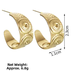 Detailed view of gold C-shaped earrings with solar patterns and 2.3cm height dimension