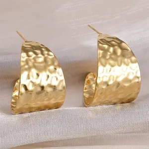 Ethnic hammered wide C-shape earrings in gold finish with irregular textured surface