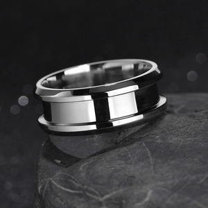 Macro shot of polished 8mm stainless steel ring with a center groove on a dark rock surface