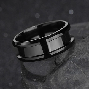 Macro detail of a high-polished 8mm black grooved ring on a textured dark mineral rock