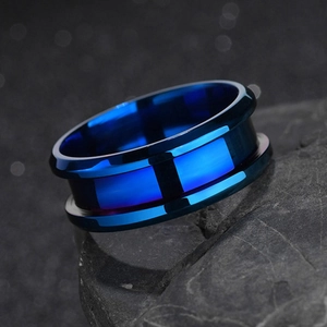 Macro shot of polished blue plated 8mm grooved stainless steel ring on a stone base
