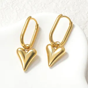 French vintage style heart drop earrings in polished gold metal on a white ceramic tray
