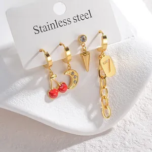Detailed macro shot of 18K gold-plated stainless steel cherry and moon mismatched earrings
