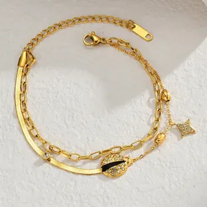 Detail of 18K gold-plated double-layer bracelet with ladybug and star charms