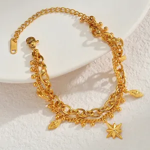 Detail of 18K gold double-layered bracelet featuring star and geometric charms
