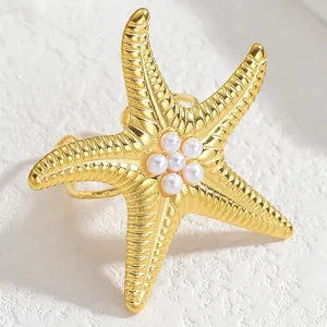 Exaggerated gold starfish open ring with pearl center and textured sea-inspired design