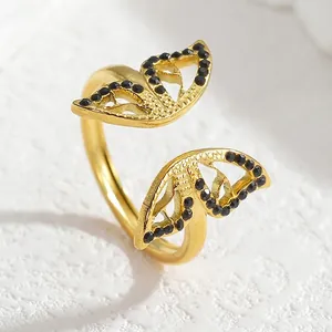 Elegant gold butterfly open ring with black crystals on a white textured background
