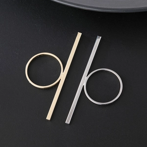 Minimalistische goldene und silberne geometrische Stabringe auf schwarzem Hintergrund