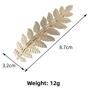 Detailed view of golden leaf hair clip showing 8.7cm length and textured leaf veins