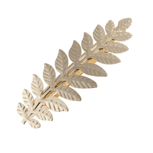 Detail of golden metal leaf hair clip with intricate branch veins and spring fastener