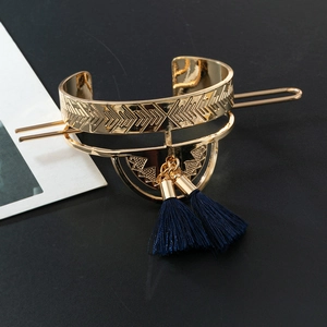 Vintage gold hair pin with hollow fan design and dark blue silk tassels on black surface