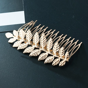 Golden metal leaf hair comb with symmetrical leaf vein design for elegant women's styling