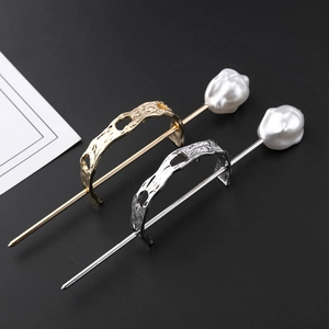 Close-up of gold and silver irregular hollow hairpins with baroque pearls on black backdrop