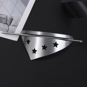 Detail of silver brushed metal hair pin with geometric triangle and star cutouts