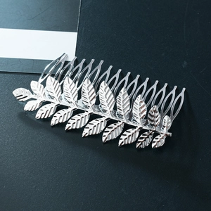 Silver metallic olive leaf hair comb clip accessory for women on a grey background
