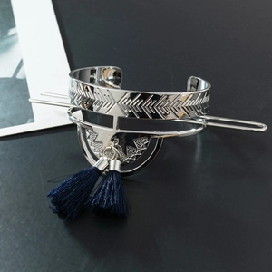 Detail of silver hair pin with geometric patterns and deep blue silk tassels