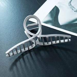 Matte silver curved metal claw clip with a twisted minimalist design for women's hair