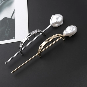 Macro detail of irregular lava texture metal hairpins with elegant baroque pearls