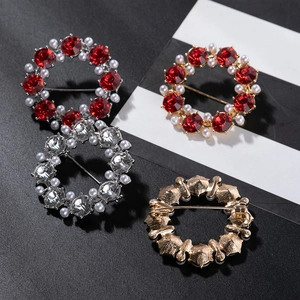 Macro detail of the round wreath brooch with vibrant red crystals and smooth pearls