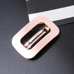 Close-up of rose gold hollow rectangle hair clip with brushed metal texture and spring