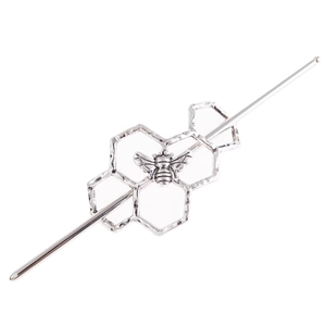 Silver metal hair pin with honeycomb frames and bee design on a white background