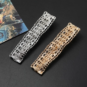 Detailed macro view of gold and silver hollow rectangle hair clips with mesh texture