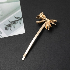 Barrette à cheveux dorée en alliage avec un design de nœud rayonnant sur fond sombre