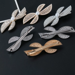 Detail view of sparkling bow hair clips with crystal rhinestones and pearls on metal base