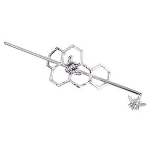 Macro detail of antique silver hair stick featuring bee and honeycomb textured design