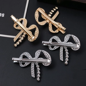 Σετ τεσσάρων κλιπ μαλλιών με διάτρητο φιόγκο και πέρλες σε χρυσό και ασημί χρώμα