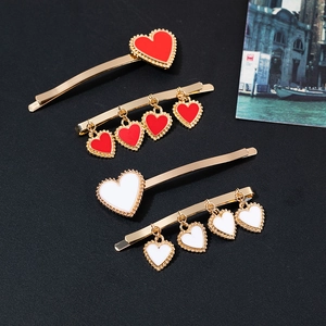 Vintage heart hair clips in gold finish with red and white enamel drip oil details