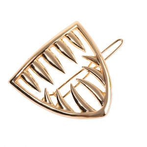 Unique geometric gold metal hair clip with a creative tooth-shaped design on white background