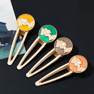 Close-up of four vintage alloy hair clips with coin relief and colorful enamel inlay