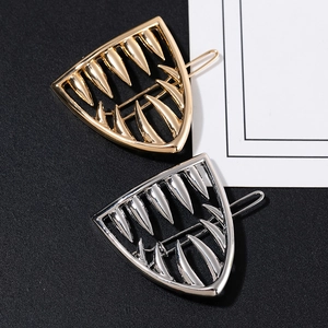 Minimalist geometric metal hair clip in fang shape featuring gold and silver finish options