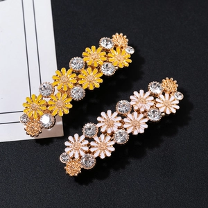 Détail de barrettes marguerites avec perles et strass sur un fond texturé et élégant