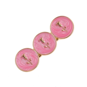 Macro detail of French vintage hair clip featuring pink marble enamel and golden roses