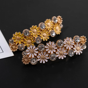 Barrettes marguerites avec perles et strass sur fond noir texturé élégant